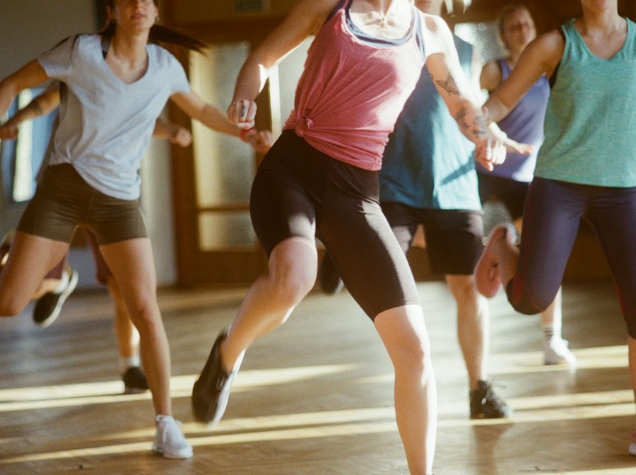 Group in gym gear mid-routine on a studio floor during a dance aerobics class